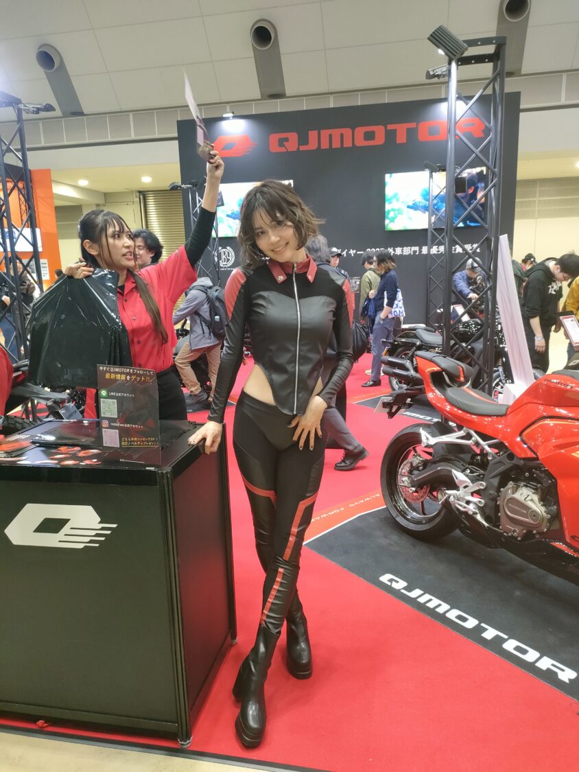 東京モーターサイクルショー2026のQJMOTORブースに立つイメージガール