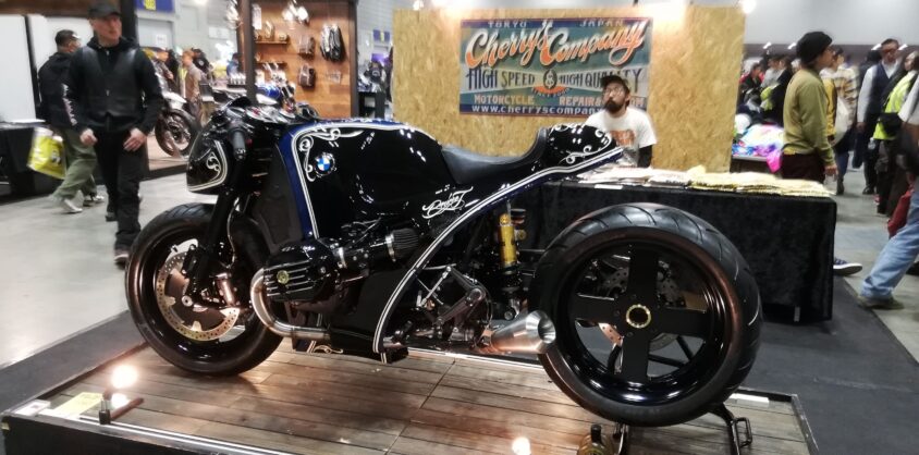 横浜ホットロッドカスタムショーのCherry's Companyのブースと黒いカスタムバイク